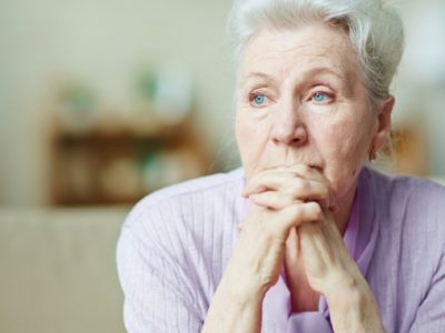 Elderly woman deep in thought