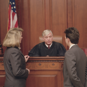 Criminal defense attorney consulting with client inside a courtroom