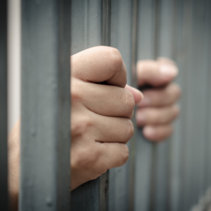 Man seen through jail bars after a vehicular offense